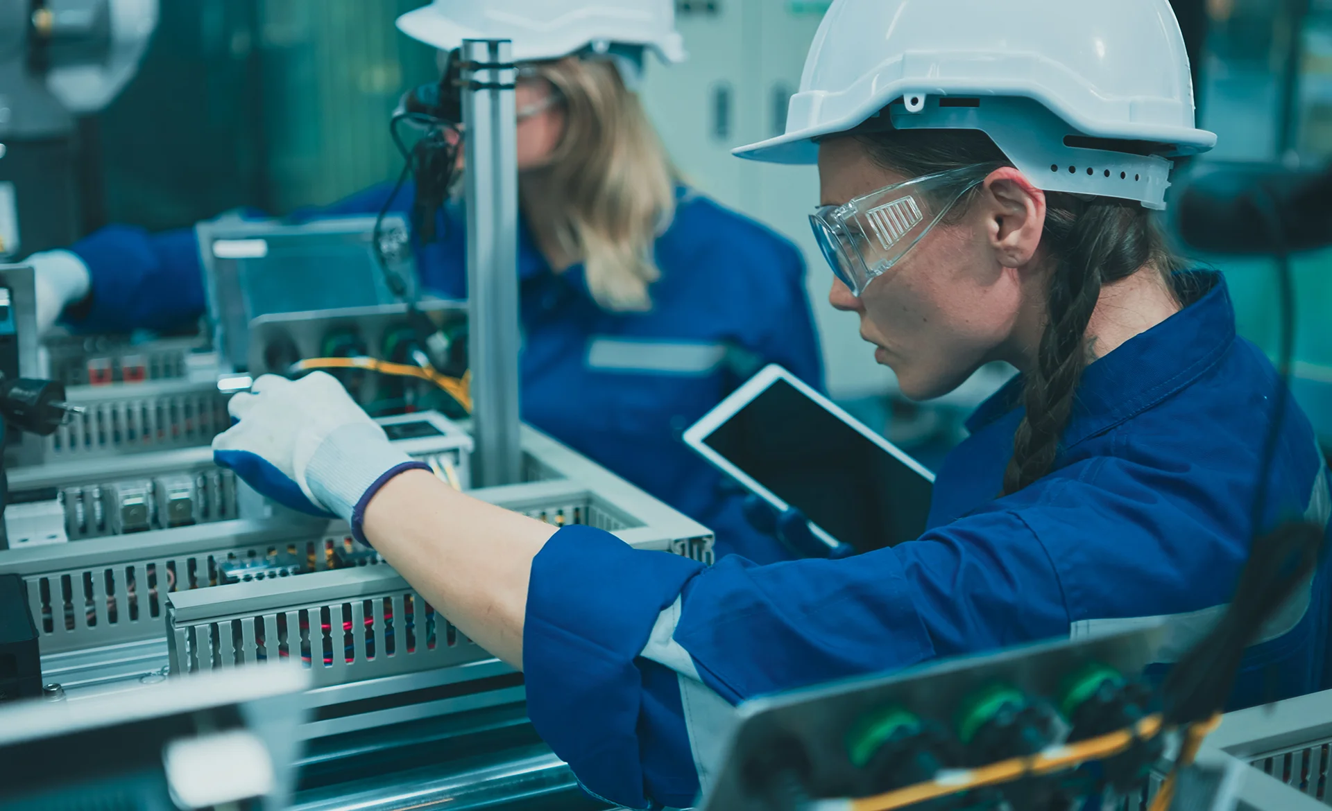 Two Females engineers using tablet Working on a machine